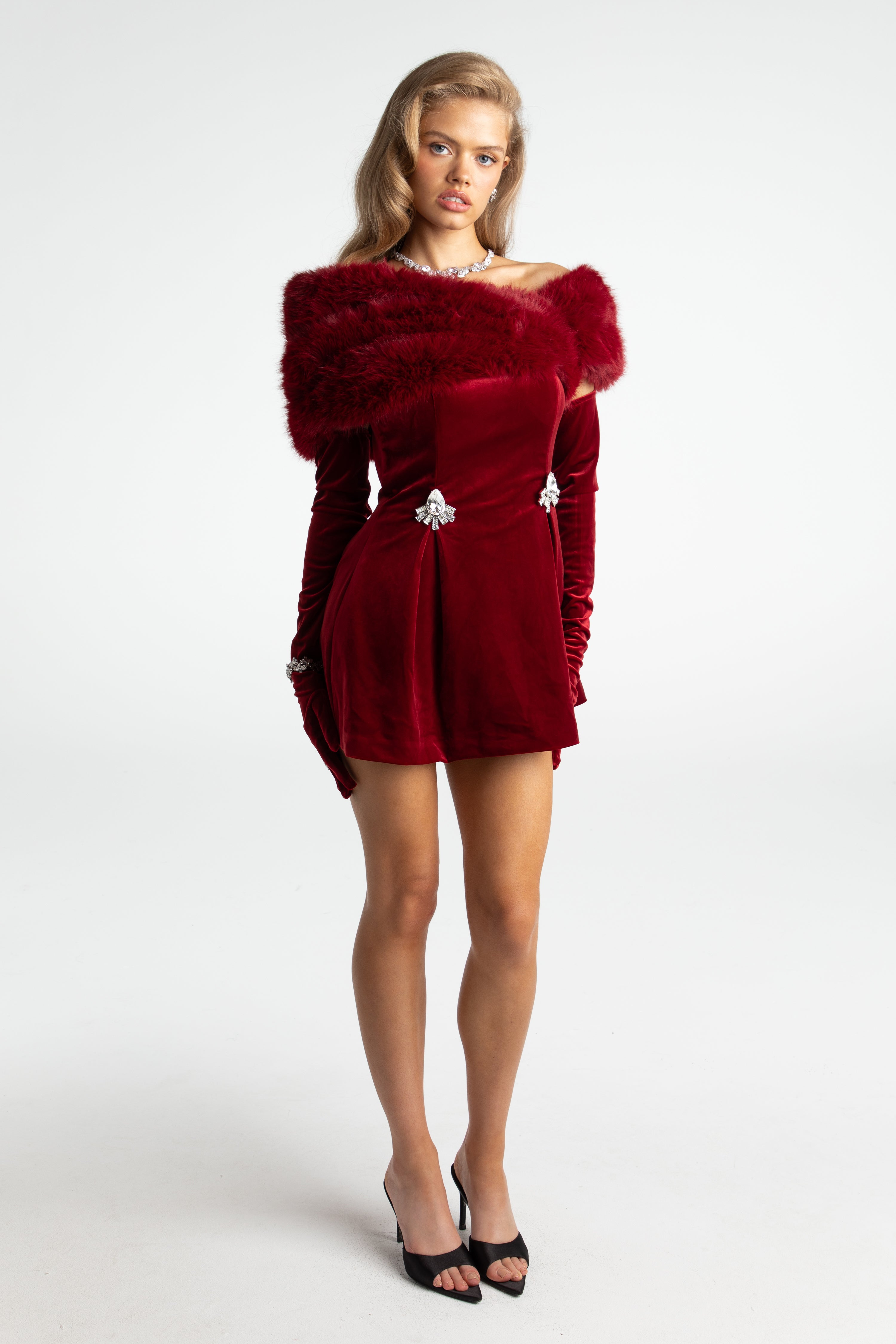 Woman wearing a red dress with fur trim on a white background