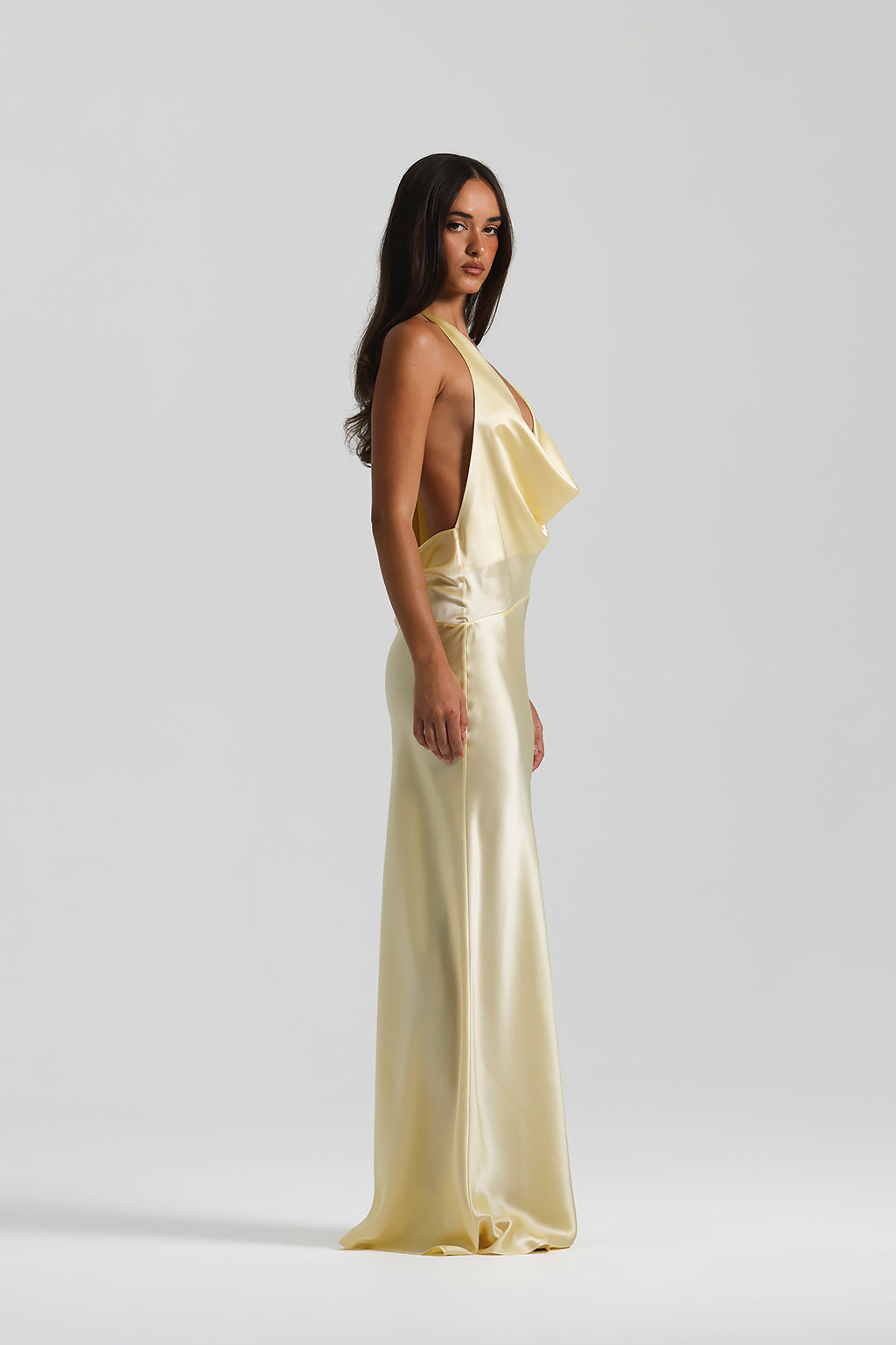 Woman wearing a yellow satin dress against a white background