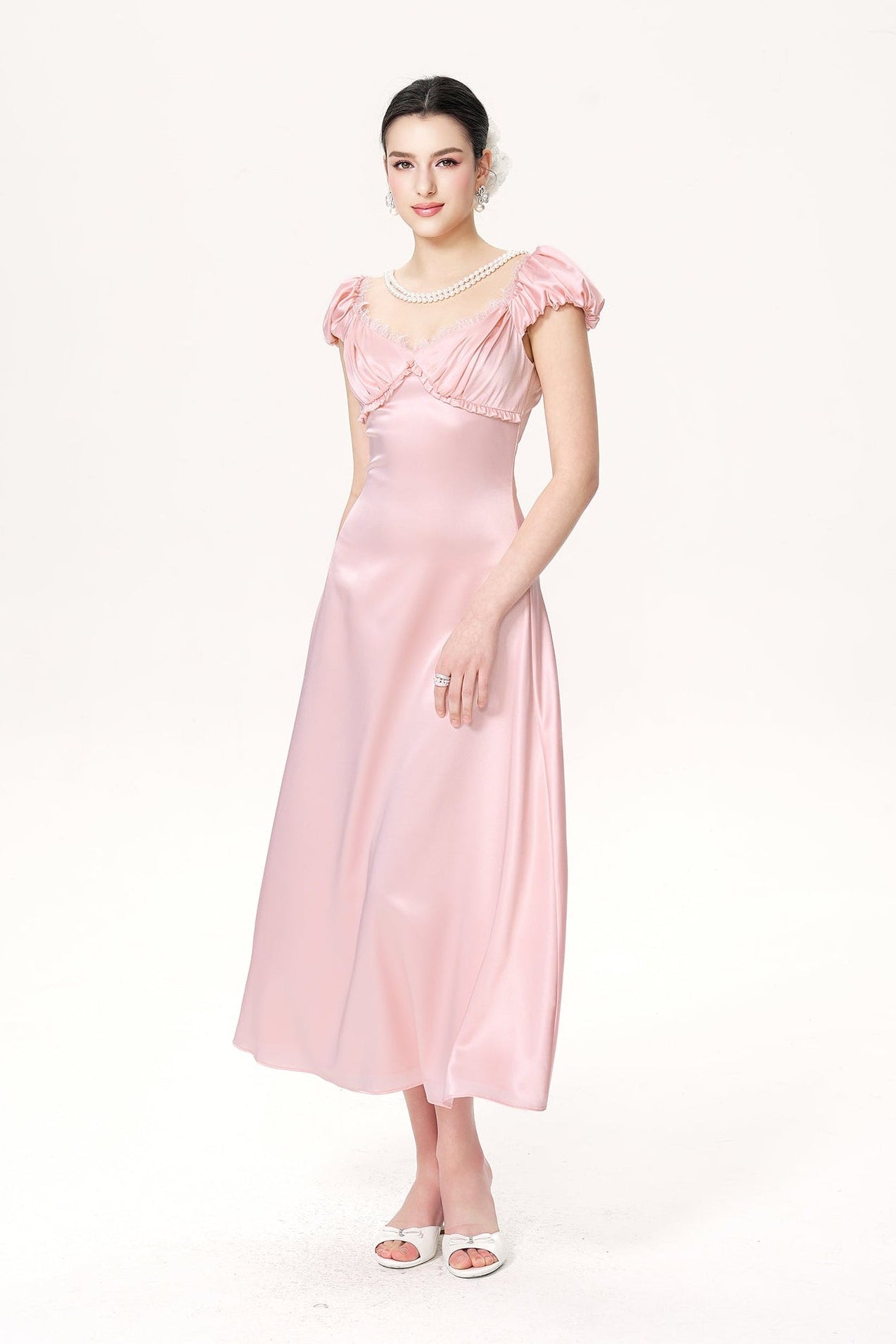 Woman wearing a pink satin dress on a white background