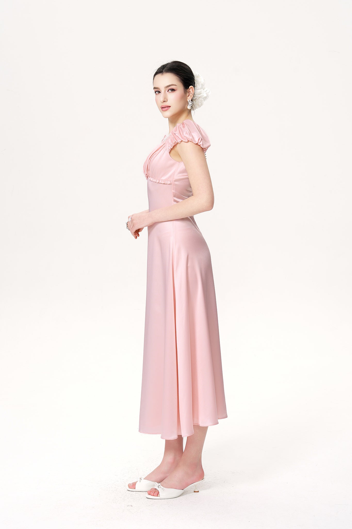 Woman wearing a pink dress on a white background