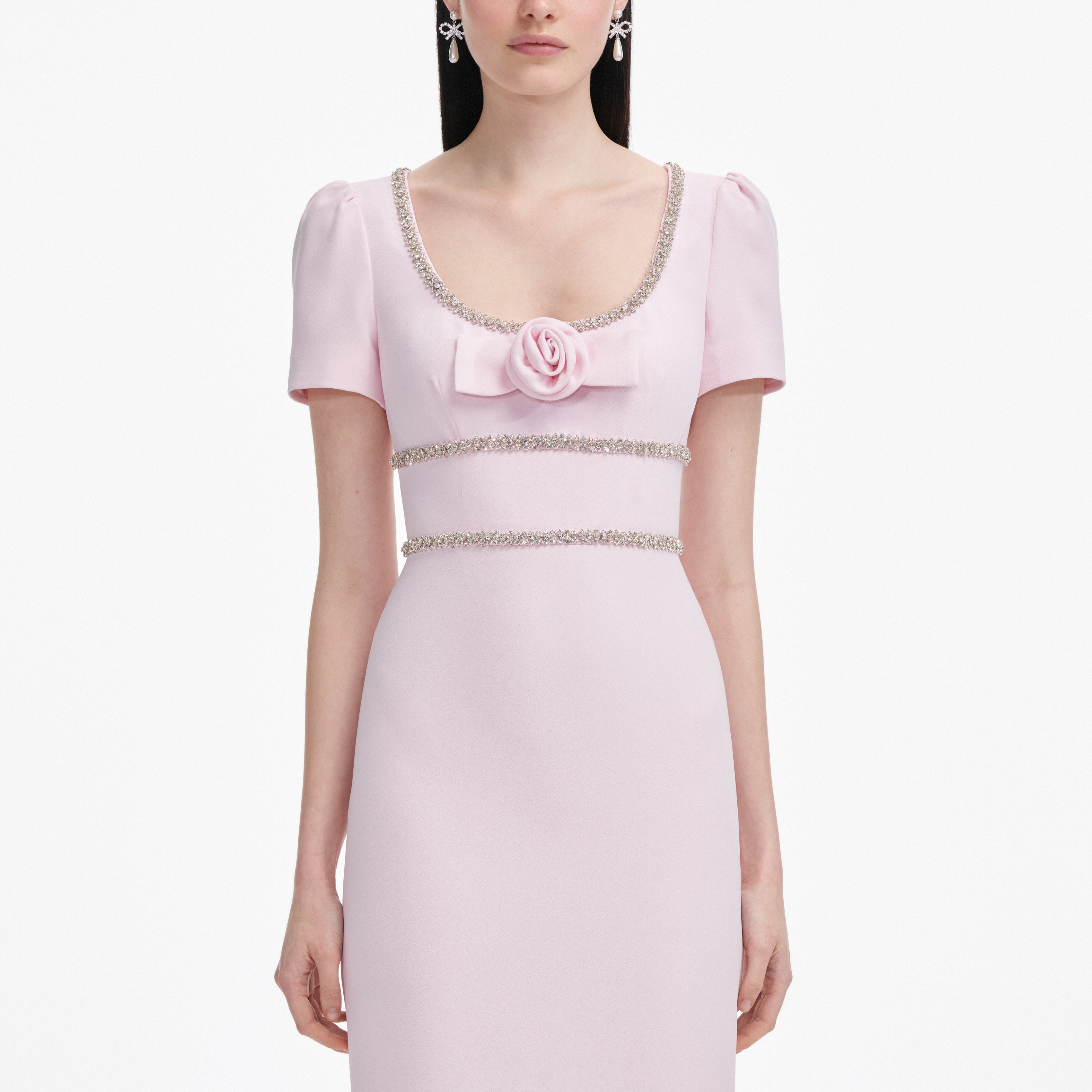 Pink dress with floral embellishments on a white background