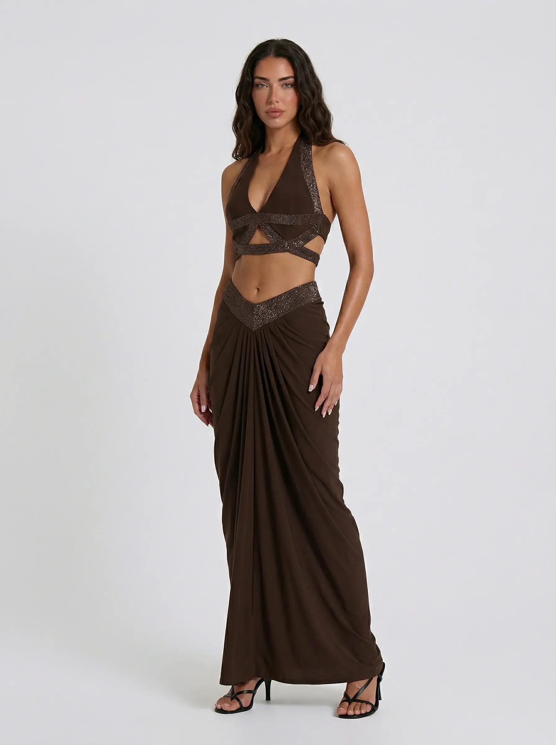 Woman wearing a brown evening gown with a deep neckline on a white background