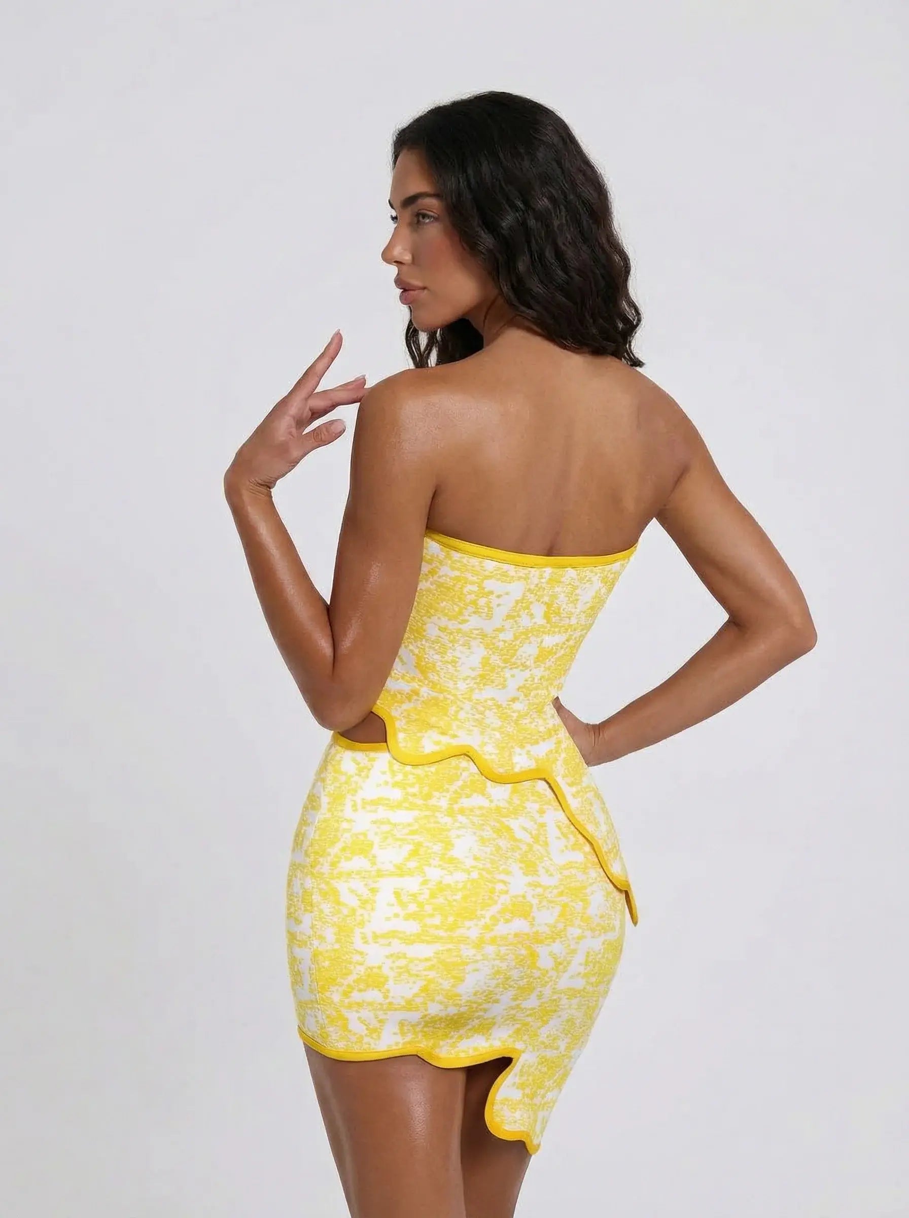 Side view of yellow jacquard two-piece set showing structured bandeau top and mini skirt silhouette by VeroMarka