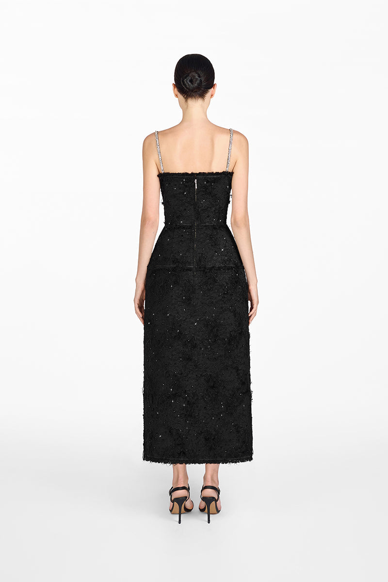 Black dress worn by a model on a white background