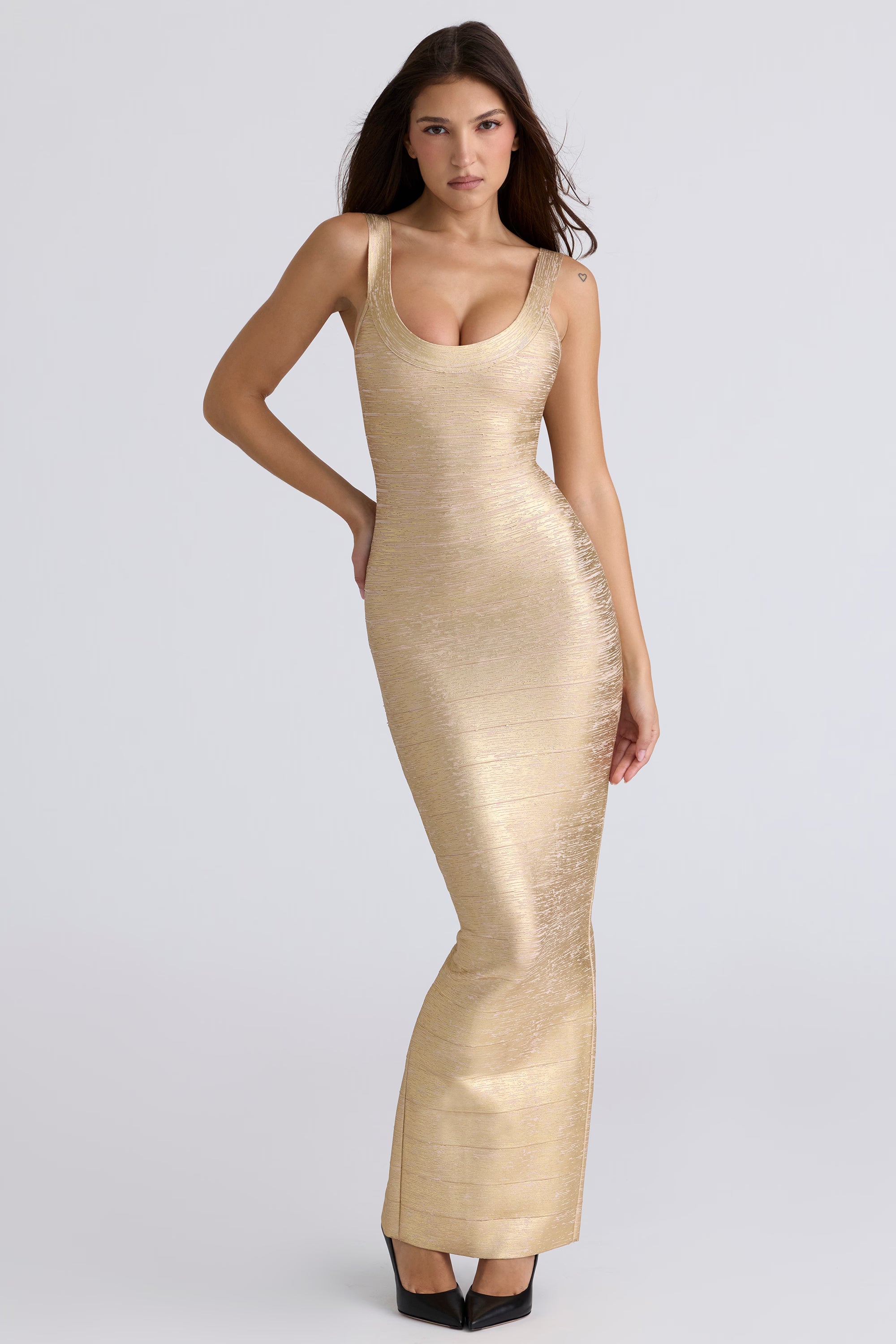 Woman wearing a gold evening gown on a light gray background
