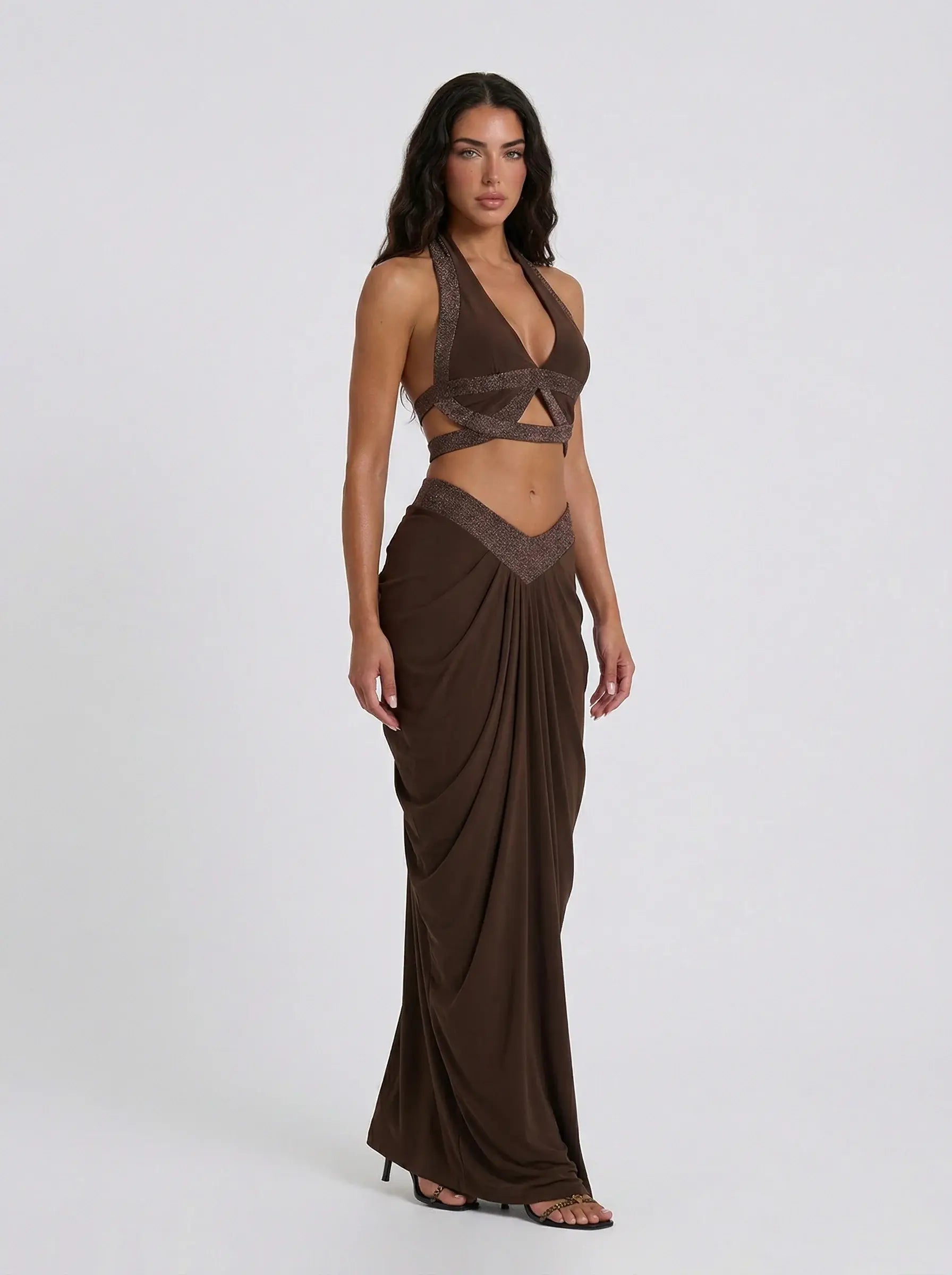 Woman wearing a brown dress with a draped skirt on a white background