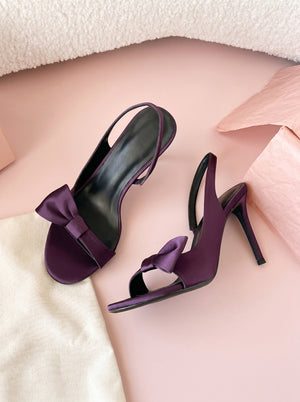 Bow Stiletto Slingback Sandal in plum purple — satin bow and slingback strap, flat lay on a linen cloth, VeroMarka