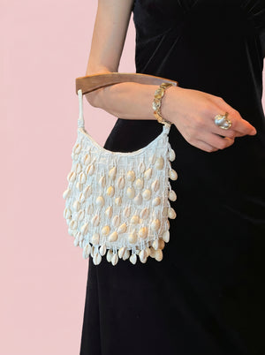 Cowrie Shell Wooden Tote in ivory — cowrie shell fringe and wooden handle, held at the side, VeroMarka
