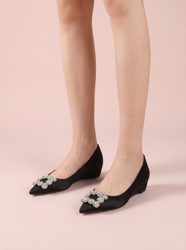 Crystal Buckle Pointed Flat in black — satin finish and crystal buckle, worn standing, close view, VeroMarka