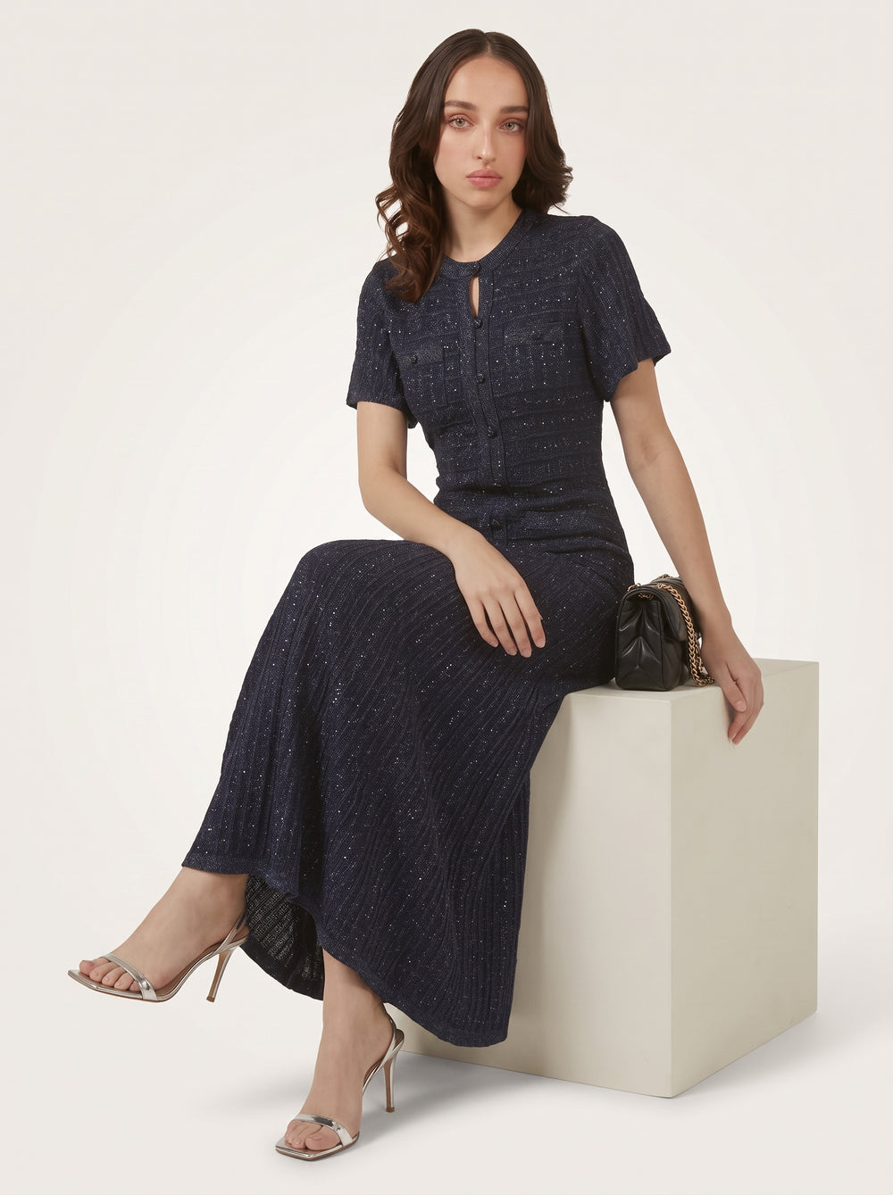 Cutout Button A-Line Dress in navy blue, seated on a cube with a quilted bag, VeroMarka