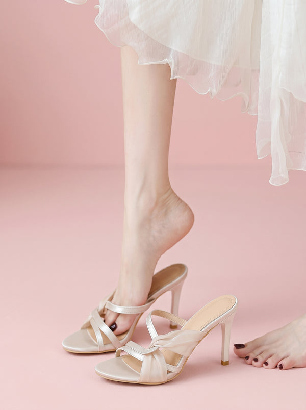 Knotted Stiletto Heeled Sandal in nude beige — satin knot and slim straps, worn while slipping the heel on, VeroMarka