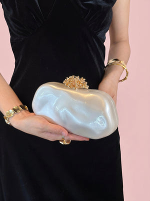 Pearl Coral Clasp Clutch in pearl white, held at the waist, alternate shot, VeroMarka