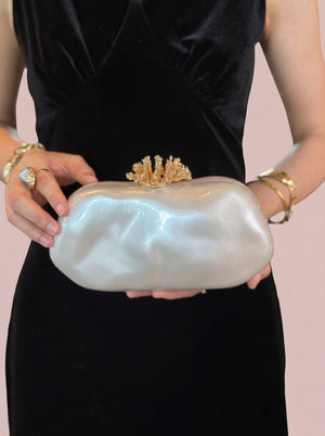 Pearl Coral Clasp Clutch in pearl white — pearlescent shell and gold coral clasp, held at the waist, VeroMarka