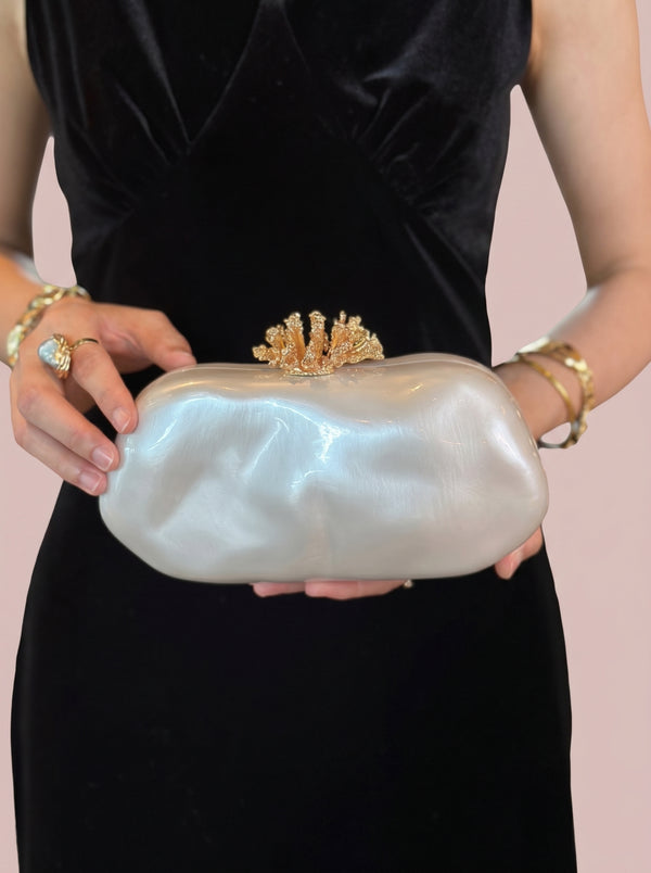 Pearl Coral Clasp Clutch in pearl white — pearlescent shell and gold coral clasp, held at the waist, VeroMarka