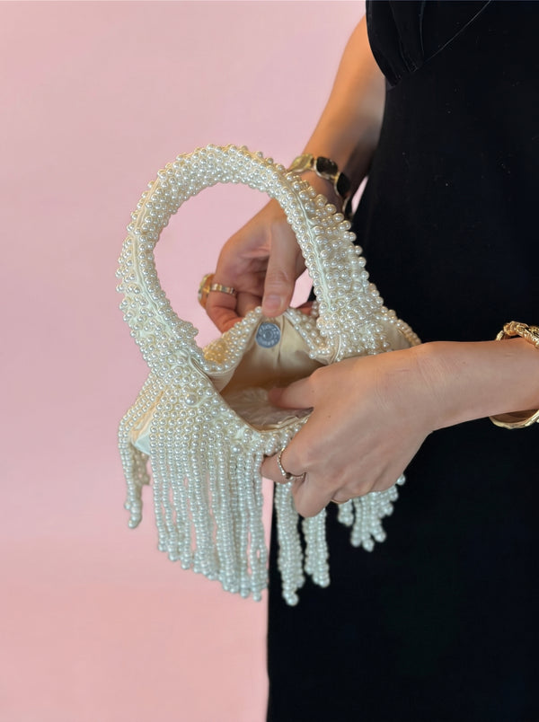 Pearl Tassel Underarm Bag in ivory pearl, held open to show the lining, VeroMarka