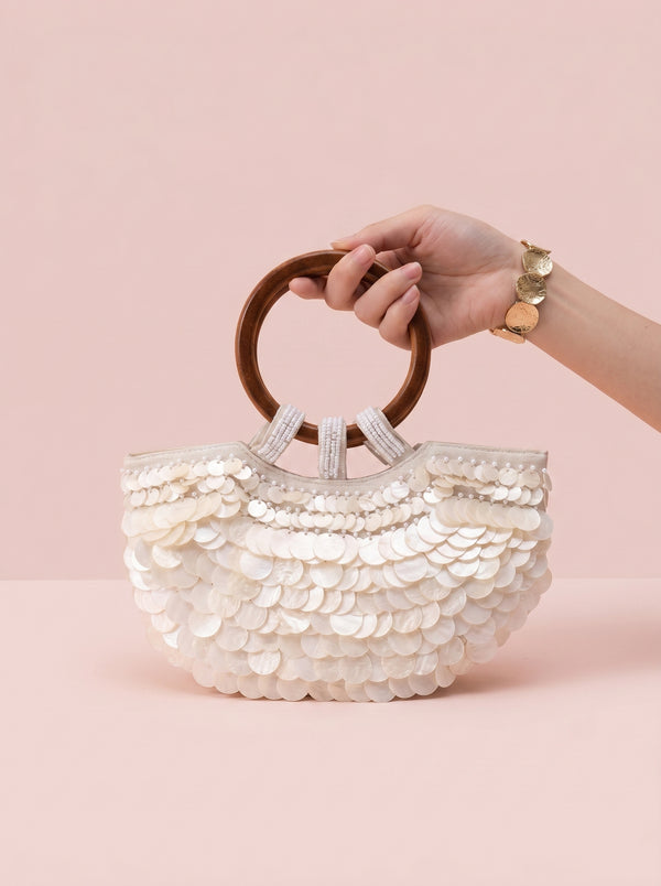 Sequin Shell Ring-Handle Bag in ivory — shell sequins and wooden ring handle, held by the wooden ring handle, VeroMarka