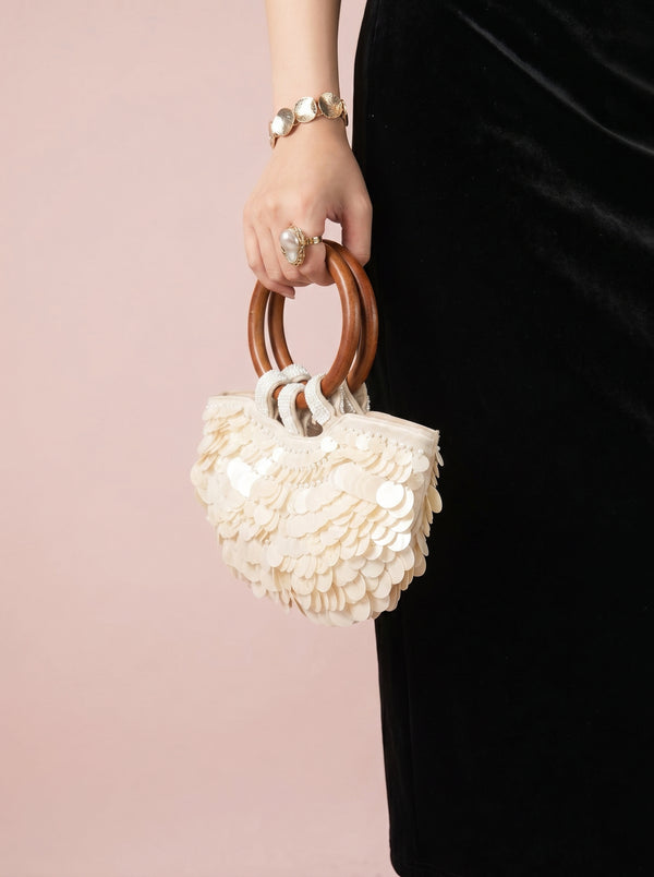 Sequin Shell Ring-Handle Bag in ivory — shell sequins and wooden ring handle, held by the ring handle, VeroMarka